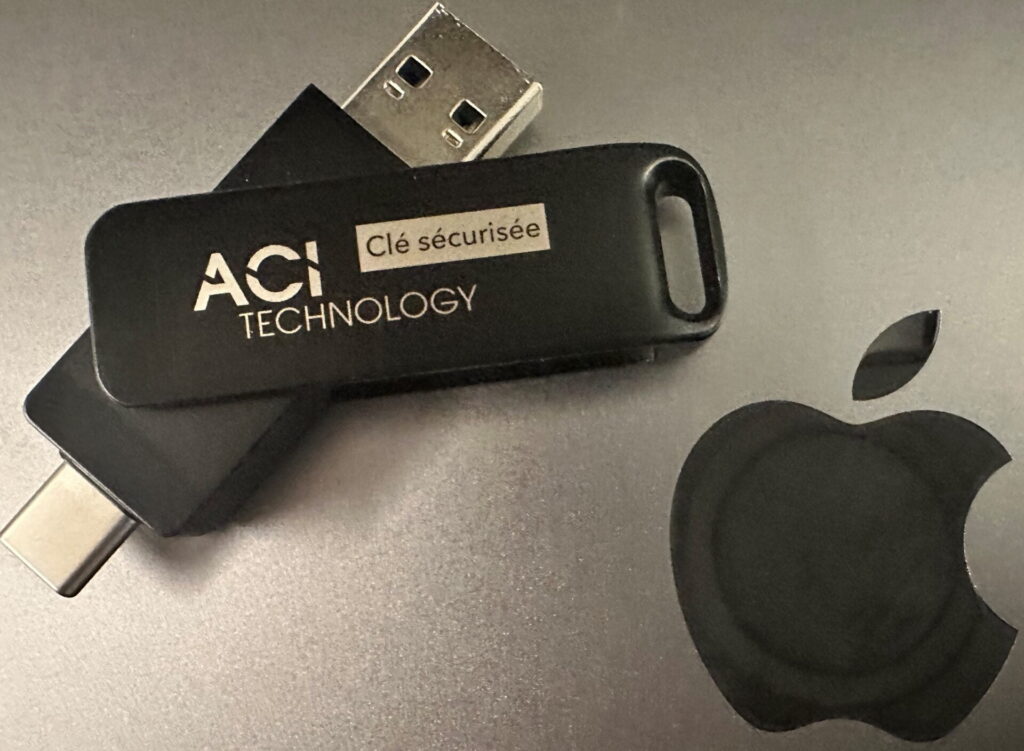 Clé USB avec connecteur USB-C posée près d'un ordinateur portable